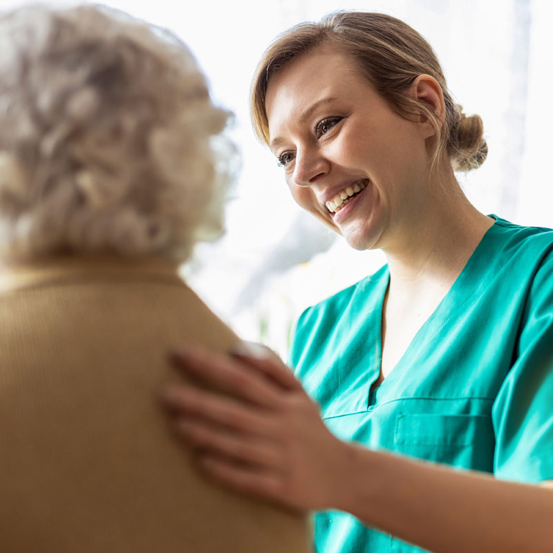 Nurse talking with an elderly female patient